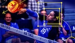 A volleyball player spikes a volleyball, and an overlay of yellow boxes, arrows, crosshairs and dotted lines trace the path of movement of the player and ball.