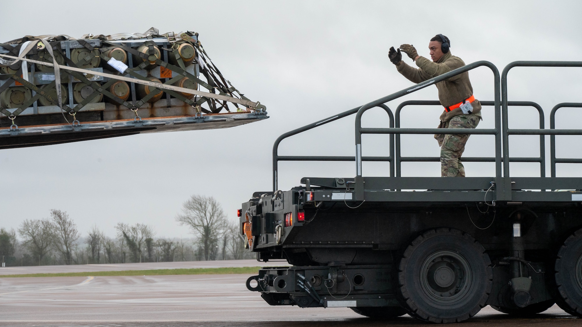 An Airman guides a pallet onto a cargo loader for airlift transport