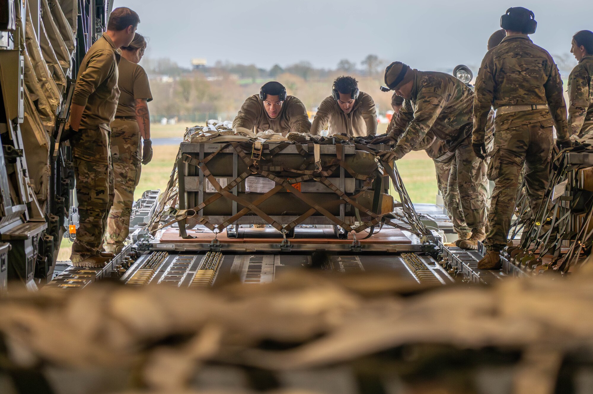 Airmen push pallets aboard a C-17 Globemaster III