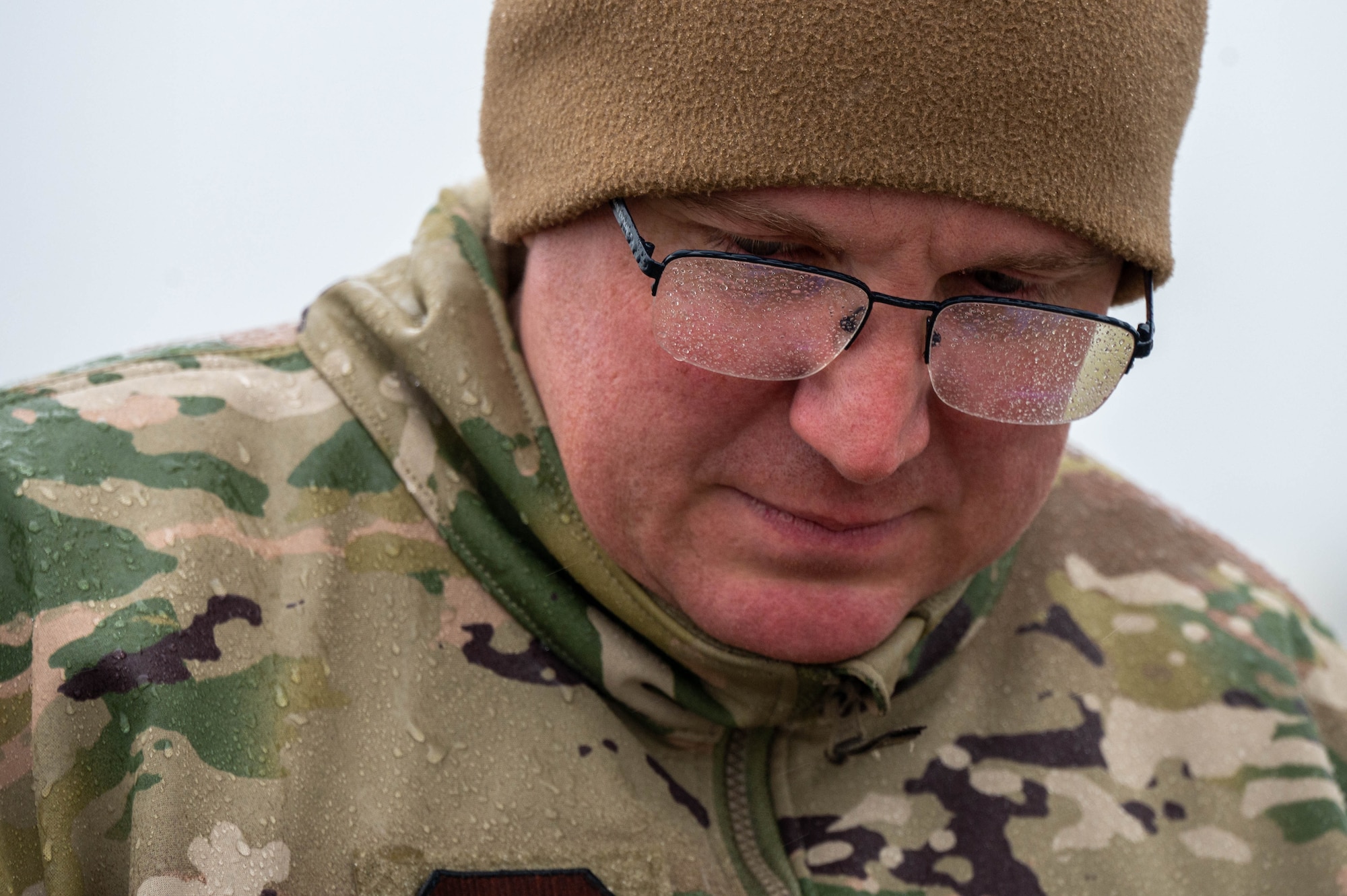 A close up of an Airman with raindrops of his glasses