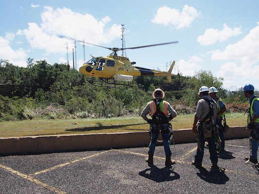 Linemen contracted by U.S. Army Corps of Engineers prepare to be sling-loaded from helicopters to inspect tops of high-voltage transmission towers and anchor lines that hold them in place after roughly 80 percent of grid was affected by storms, Aguadilla Pueblo, Puerto Rico, February 16, 2018 (U.S. Army Corps of Engineers/Michael N. Meyer)