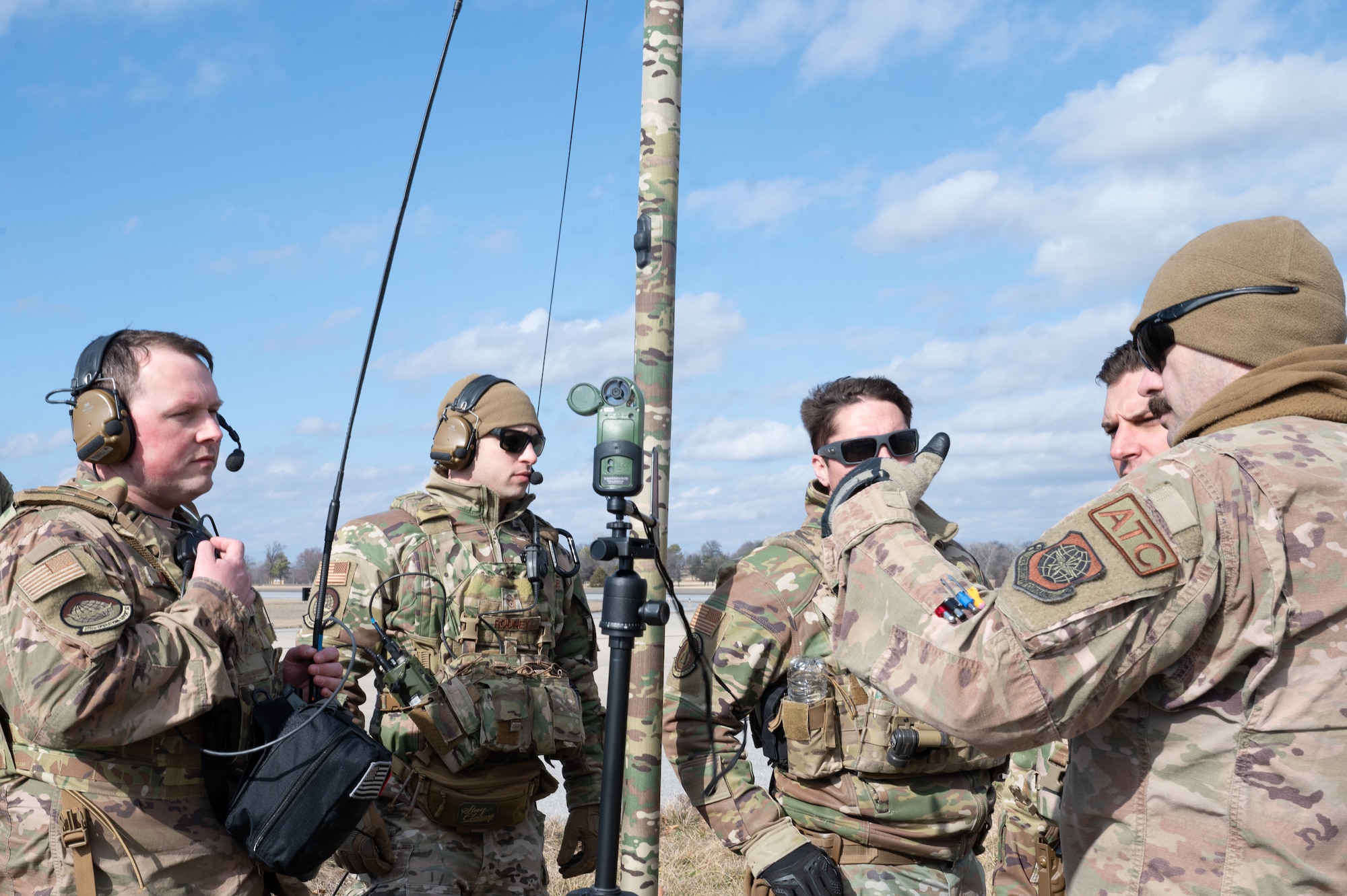 TSgt. Marple stands with four other Airmen, who are circled around a wind sensor