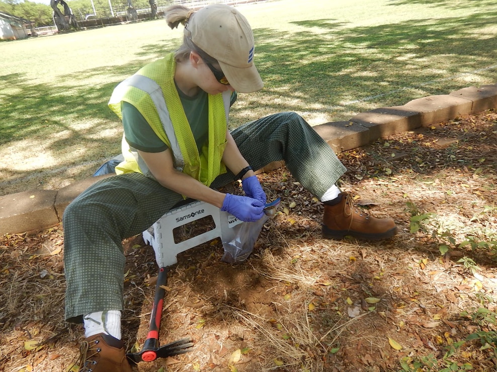 A contractor takes a surface sample from a tree planter area next to the practice field at Radford High School in 2017.