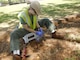 A contractor takes a surface sample from a tree planter area next to the practice field at Radford High School in 2017.