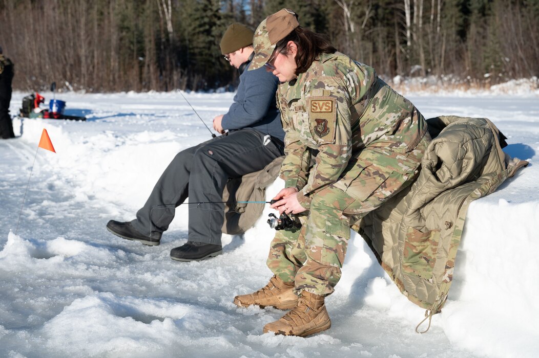 U.S. Air Force Tech. Sgt. Kathy Hernandez, 354th Force Support Squadron food section chief, ice fishes at Eielson Air Force Base, Alaska, Feb. 14, 2024.