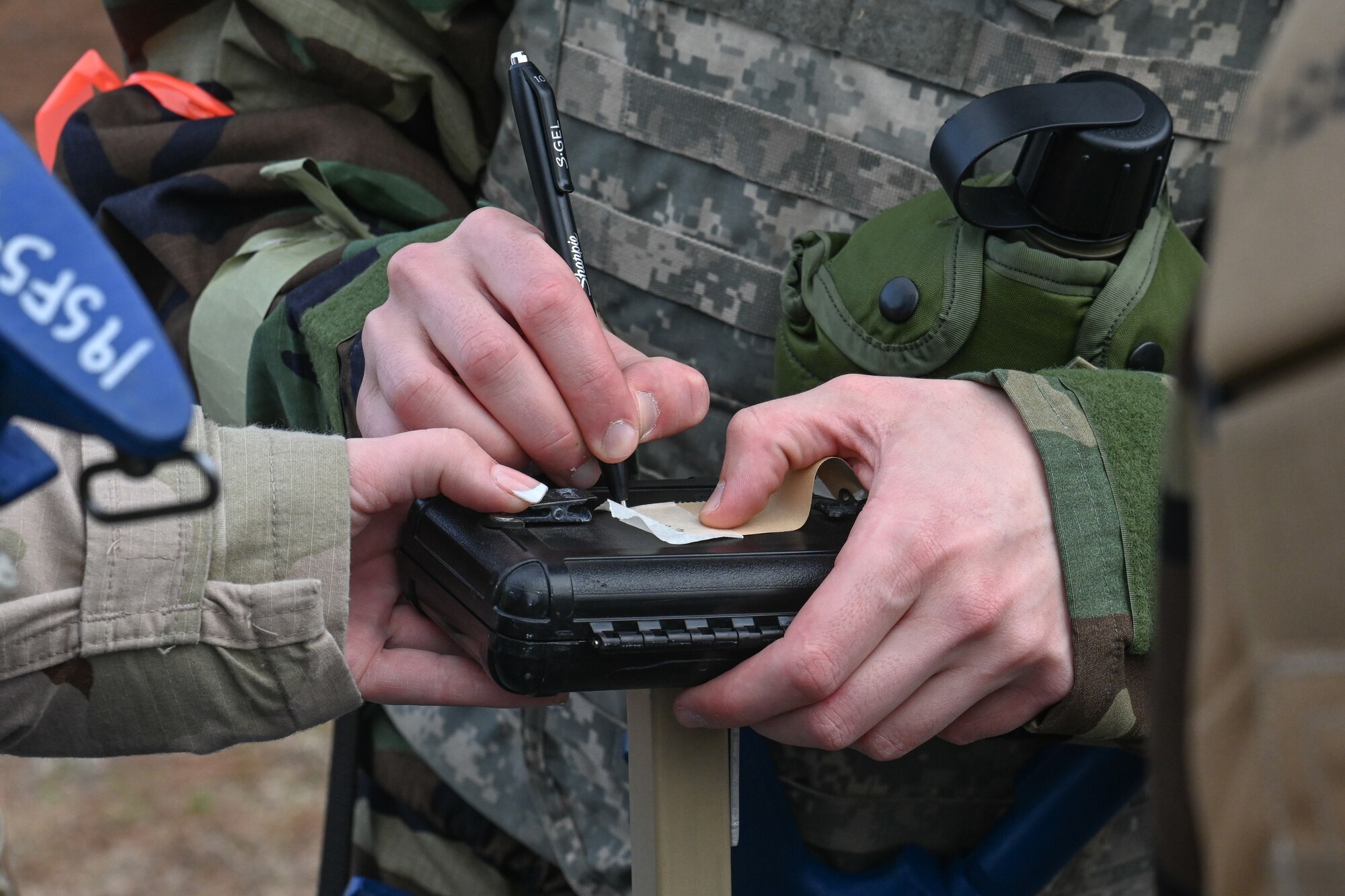 An Airman writes on a M8 Chemical Detection Paper.