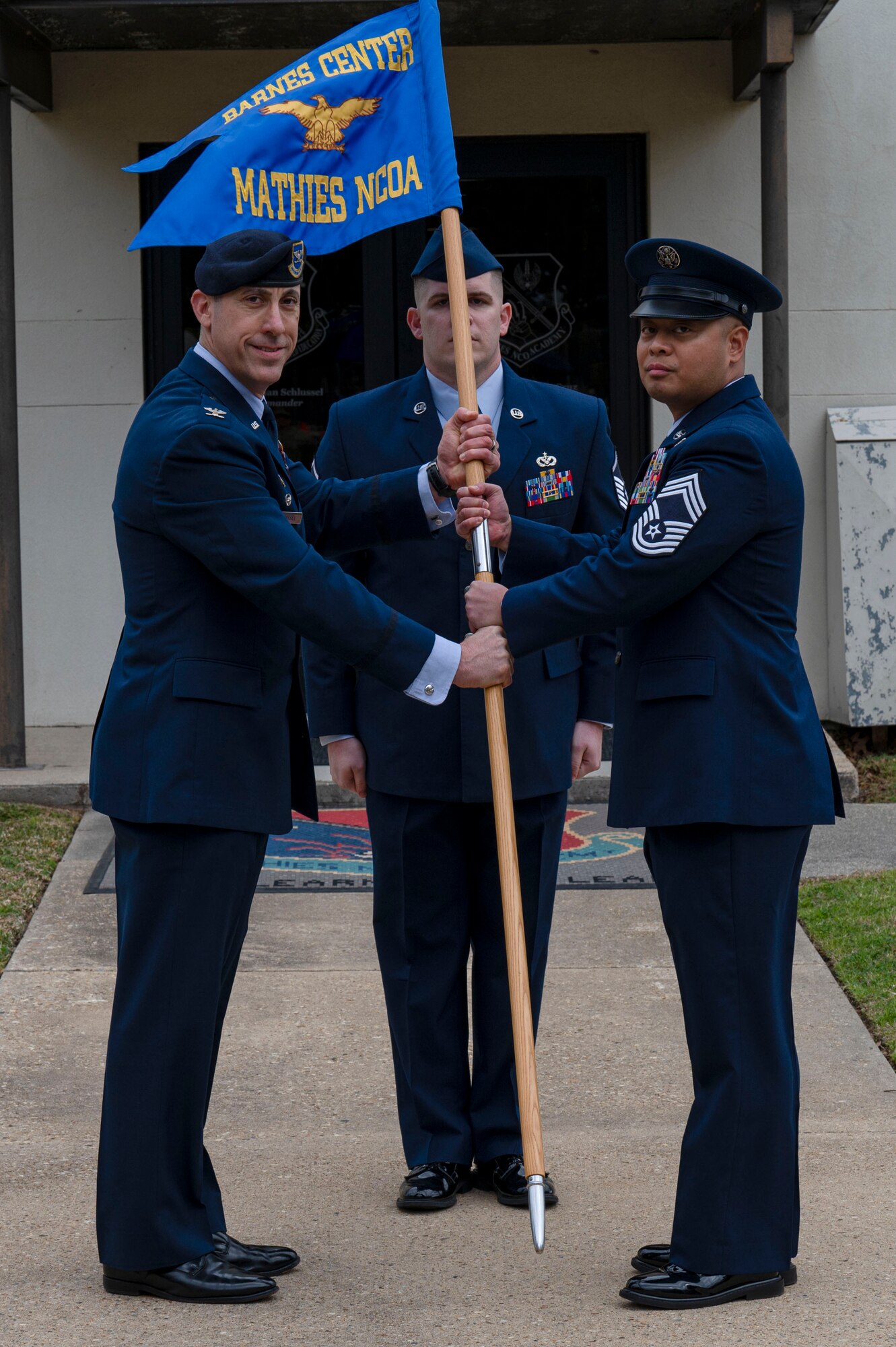 U.S. Air Force Col. Damian Schlussel, Thomas N. Barnes Center for Enlisted Education commander, and Chief Master Sgt. Jayar Dela Cruz, Mathies Noncommissioned Officer Academy commandant, pose for photo during the assumption of responsibility and ribbon cutting ceremony on Keesler Air Force Base, Mississippi, Feb. 8, 2024.