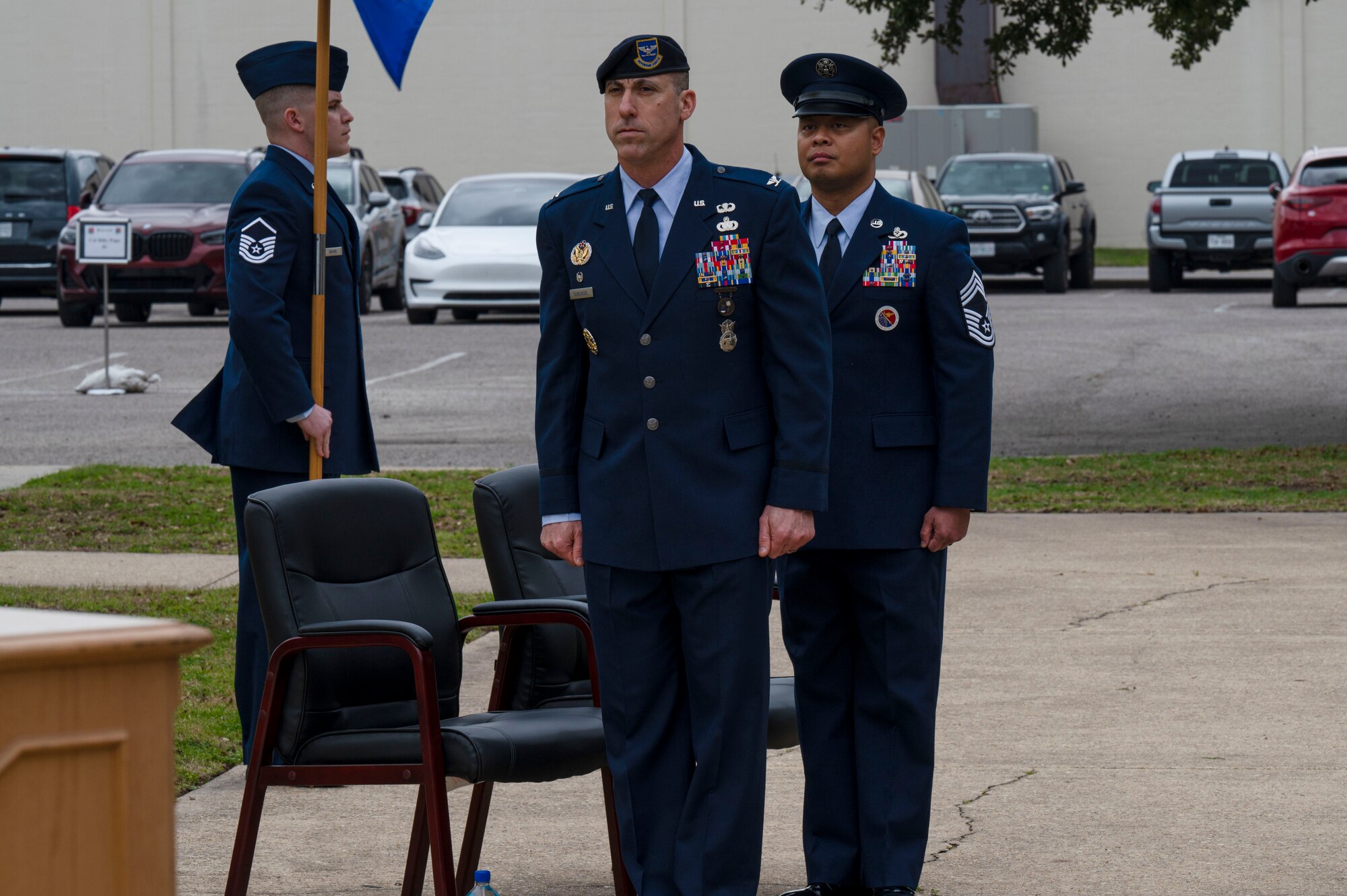 U.S. Air Force Col. Damian Schlussel, Thomas N. Barnes Center for Enlisted Education commander, and Chief Master Sgt. Jayar Dela Cruz, Mathies Noncommissioned Officer Academy commandant, stand at the position of attention during the assumption of responsibility and ribbon cutting ceremony on Keesler Air Force Base, Mississippi, Feb. 8, 2024.