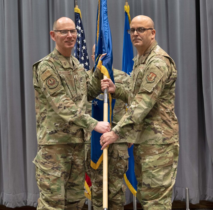 Gen. Duke Z. Richardson, left, Commander, Air Force Materiel Command, hands the command colors to Chief Master Sgt. James (Bill) E. Fitch II.