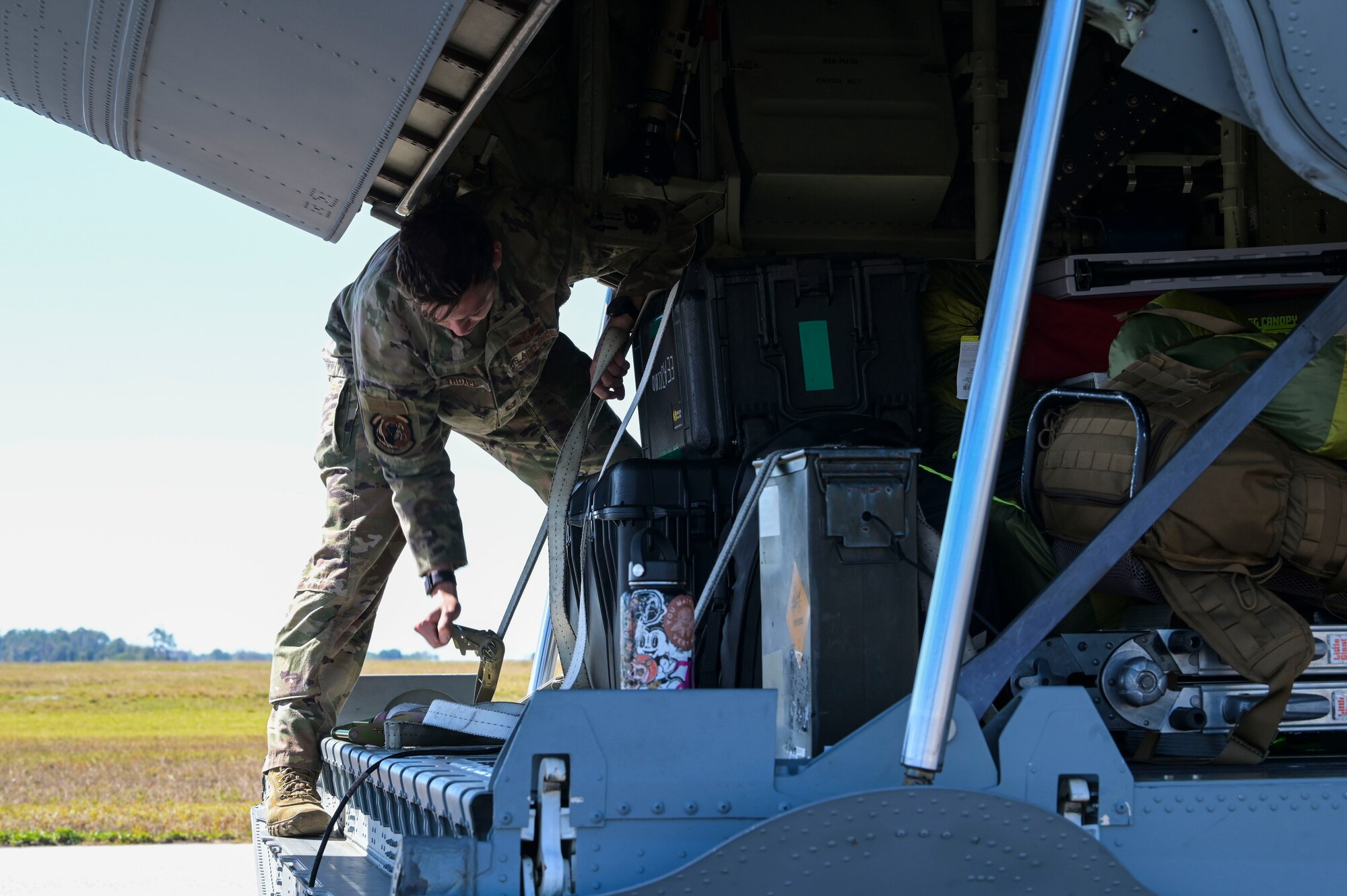 U.S. Air Force Tech. Sgt. Cody Troxel, a 73rd Special Operations Squadron special mission aviator, uses tiedown straps to secure luggage on an AC-130J Ghostrider gunship during Agile Ghost at Macdill Air Force Base.