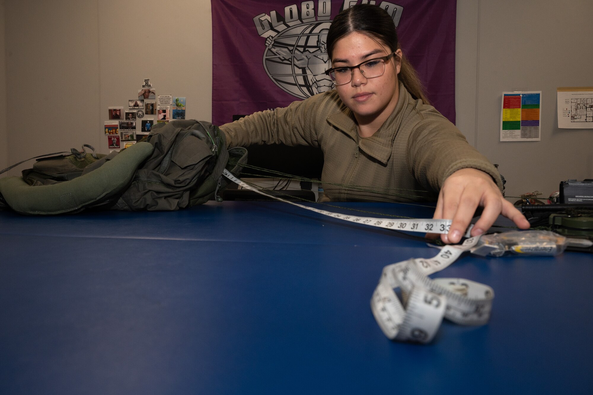 U.S. Air Force Airman 1st Class Tia Heyob, 356th aircrew flight equipment journeymen, assists the 355th Fighter Squadron by measuring connecting wires on a pilot's flight suit on Eielson Air Force Base, Alaska, Feb. 14, 2024.