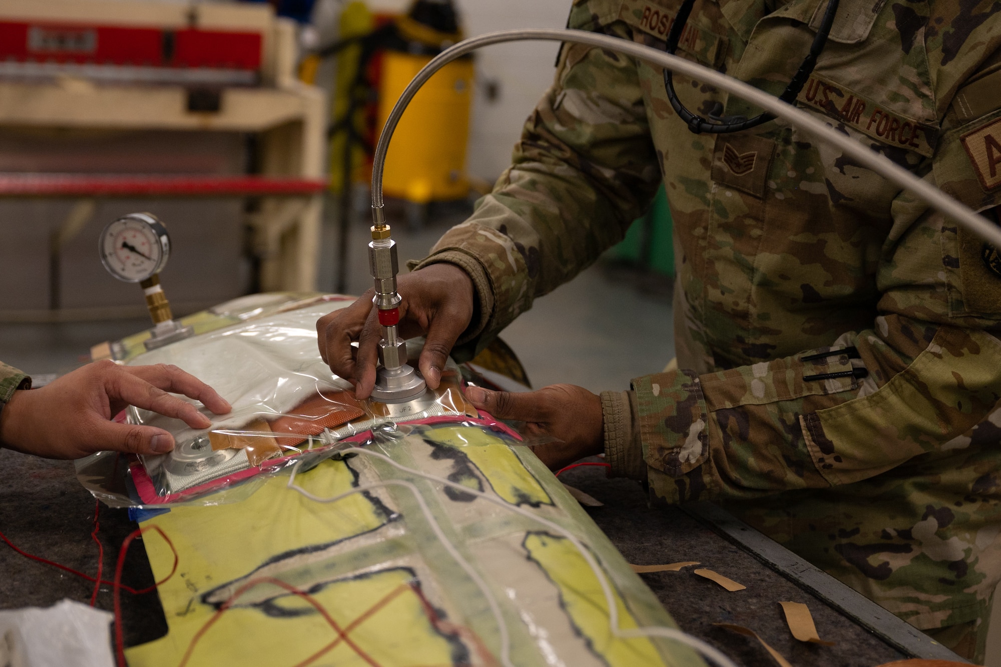 U.S. Air Force Staff Sgt. Alan Roseman, 51st Maintenance Squadron aircraft structural maintenance craftsman, prepares a vacuum seal hose at Osan Air Base, Republic of Korea, Feb. 8, 2024. The pressure going through the hose is regulated to ensure a smooth, seamless seal of fiberglass laid on the structure. Precision in structural aircraft maintenance is paramount to guaranteeing peak performance of 51st Fighter Wing aircraft. (U.S. Air Force photo by Senior Airman Brittany Russell)