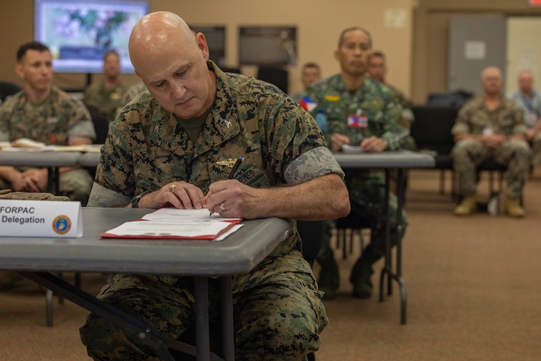 U.S. Marine Corps Col. Christopher Oliver, assistant chief of staff, G-5, U.S. Marine Corps Forces, Pacific, signs a certificate finalizing staff talks between U.S. and Philippine Marines on Camp H.M. Smith, Hawaii, Feb. 15, 2024. These annual meetings promote military interoperability, strengthen relationships, and expand military capabilities among participating forces in the advancement of a Free and Open Indo-Pacific. (U.S. Marine Corps photo by Lance Cpl. Matthew Benfield)