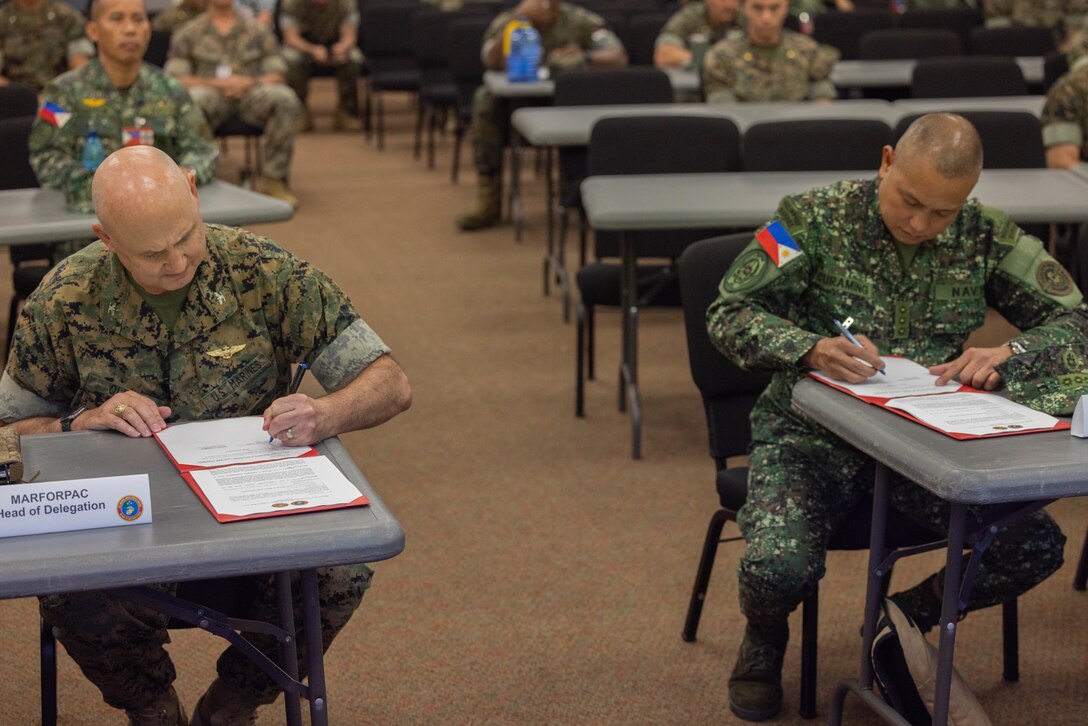 U.S. Marine Corps Col. Christopher Oliver, left, assistant chief of staff, G-5, U.S. Marine Corps Forces, Pacific, and Philippine Marine Corps Col. Bayani Curaming, Chief of Philippine Marine Staff, sign a certificate finalizing staff talks on Camp H.M. Smith, Hawaii, Feb. 15, 2024. These annual meetings promote military interoperability, strengthen relationships, and expand military capabilities among participating forces in the advancement of a Free and Open Indo-Pacific. (U.S. Marine Corps photo by Lance Cpl. Matthew Benfield)