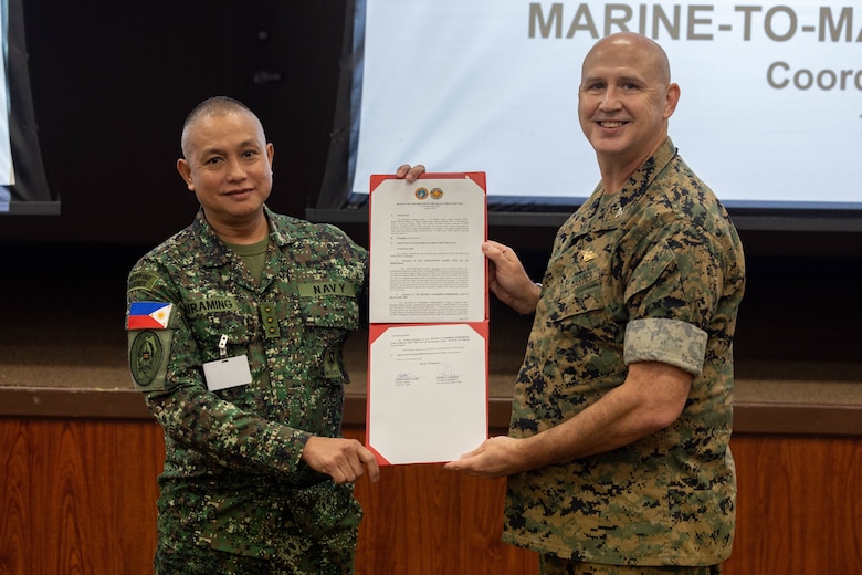 U.S. Marine Corps Col. Christopher Oliver, right, assistant chief of staff, G-5, U.S. Marine Corps Forces, Pacific, and Philippine Marine Corps Col. Bayani Curaming, Chief of Philippine Marine Staff, present a certificate finalizing staff talks on Camp H.M. Smith, Hawaii, Feb. 15, 2024. These annual meetings promote military interoperability, strengthen relationships, and expand military capabilities among participating forces in the advancement of a Free and Open Indo-Pacific. (U.S. Marine Corps photo by Lance Cpl. Matthew Benfield)