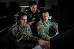 U.S. Space Force Maj. Jerra Brown, National Space Defense Center director of force development, U.S. Navy Lt. Matthew Dring, NSDC space planner, and U.S. Army Maj. Mitchell Daugherty, NSDC special technical operations chief and chief of combat operations, look at a computer screen in support of Keen Edge 24 at Schriever Space Force Base, Colo., Feb. 8, 2024. Members of the NSDC supported KE24 both at home and in Hawaii. KE24 is designed to increase integrated joint operational capability, refine command and control procedures, and improve interoperability among the participating countries to respond to a variety of crises and contingencies in the Indo-Pacific region. (U.S Space Force photo by Tiana Williams)