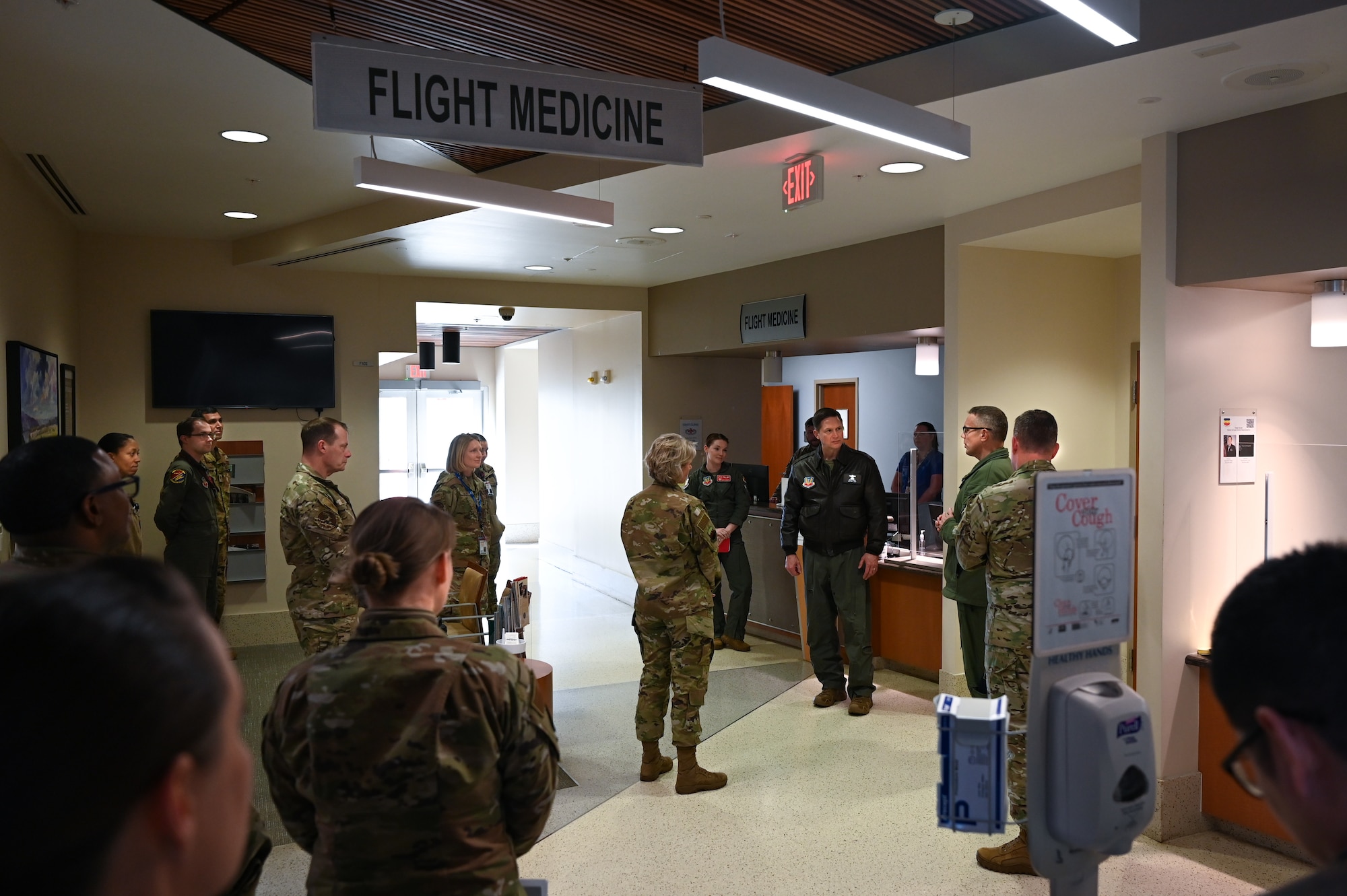 Medical active duty personnel gather and speaks to visitor.