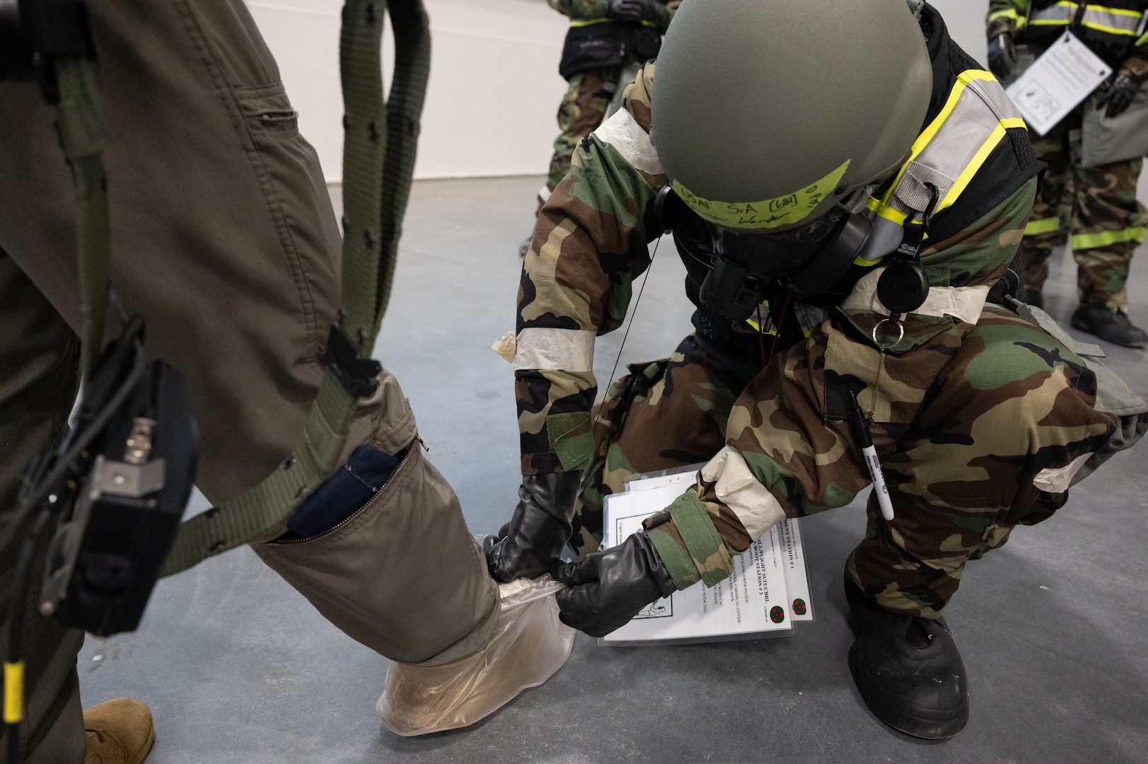 Airmen from the 155th Air Refueling Wing perform a simulated uniform decontamination of the specialized suit as part of the Mission-Oriented Protective Postures gear during a large-scale readiness exercise Feb. 4, 2024, on National Guard airbase in Lincoln, Nebraska.