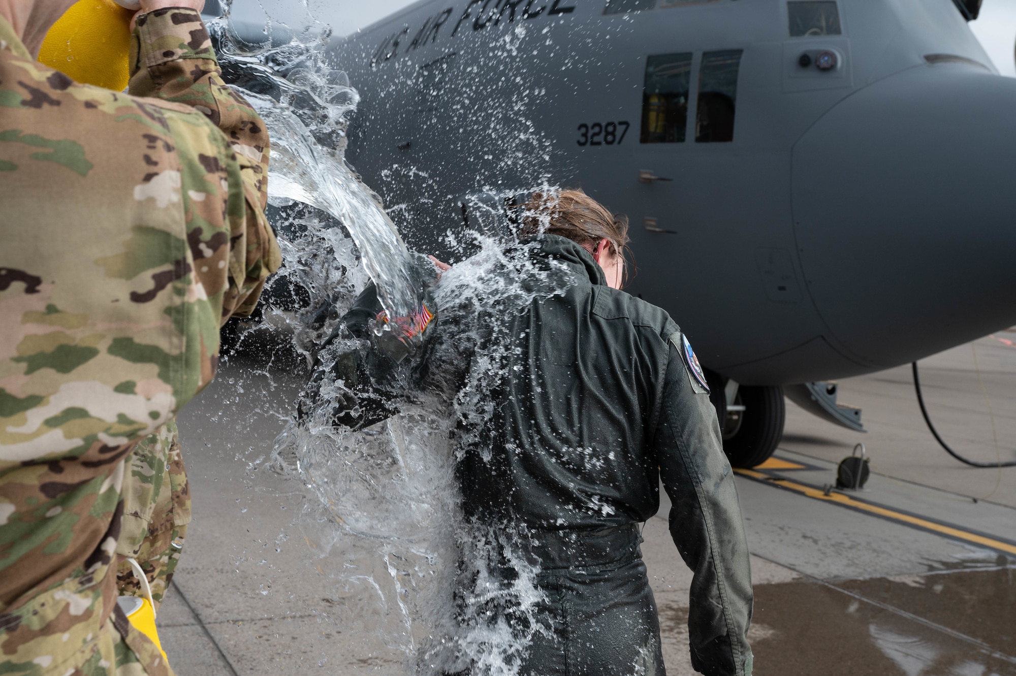 Airmen gets water thrown on them in celebration of their fini flight.