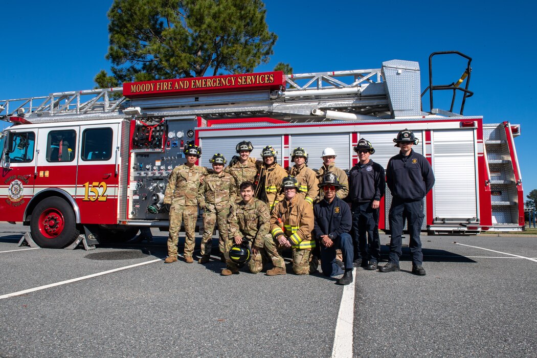 a group of firefighters stand together in front of a firetruck