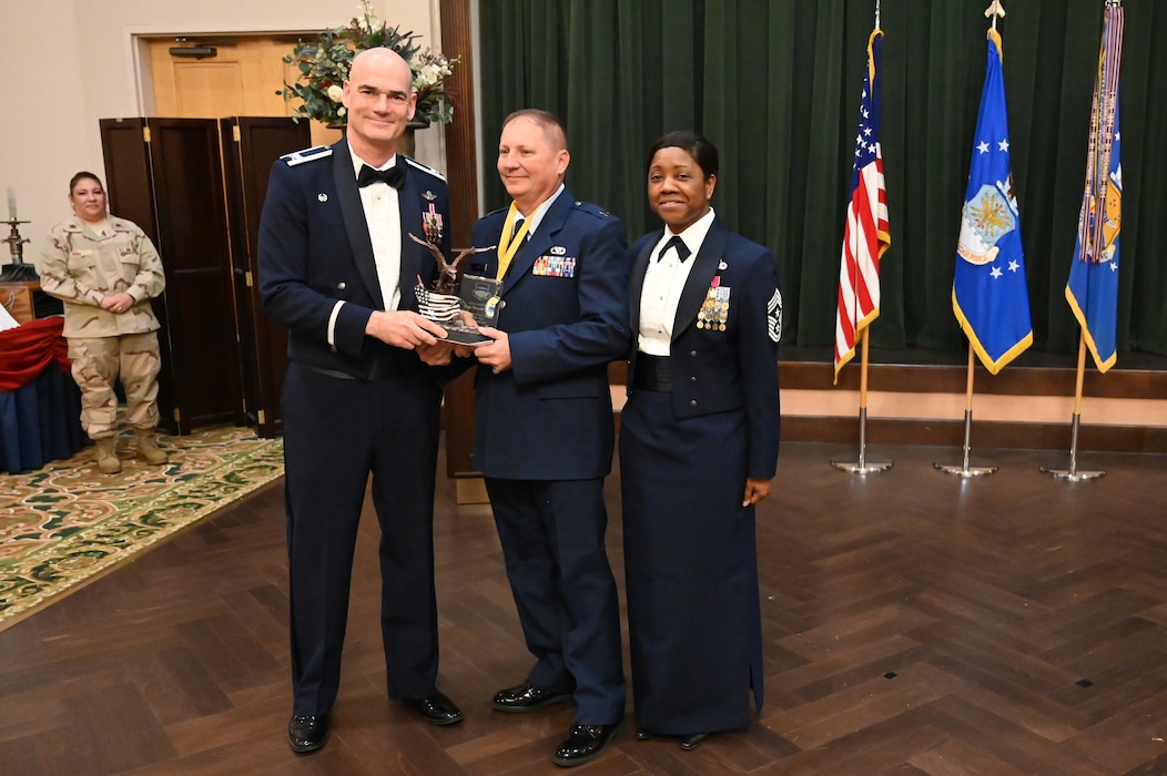 Col. William Gutermuth, 433rd Airlift Wing commander, and Chief Master Sgt. Takesha Williams, 433rd AW command chief, present the Company Grade Officer of the Year award to Capt. Donald Ahlin, 433rd Logistics Readiness Squadron, at the wing’s annual awards ceremony Feb. 3, 2024, at Joint Base San Antonio-Lackland, Texas. (U.S. Air Force photo by Tech. Sgt. Jacob Lewis)