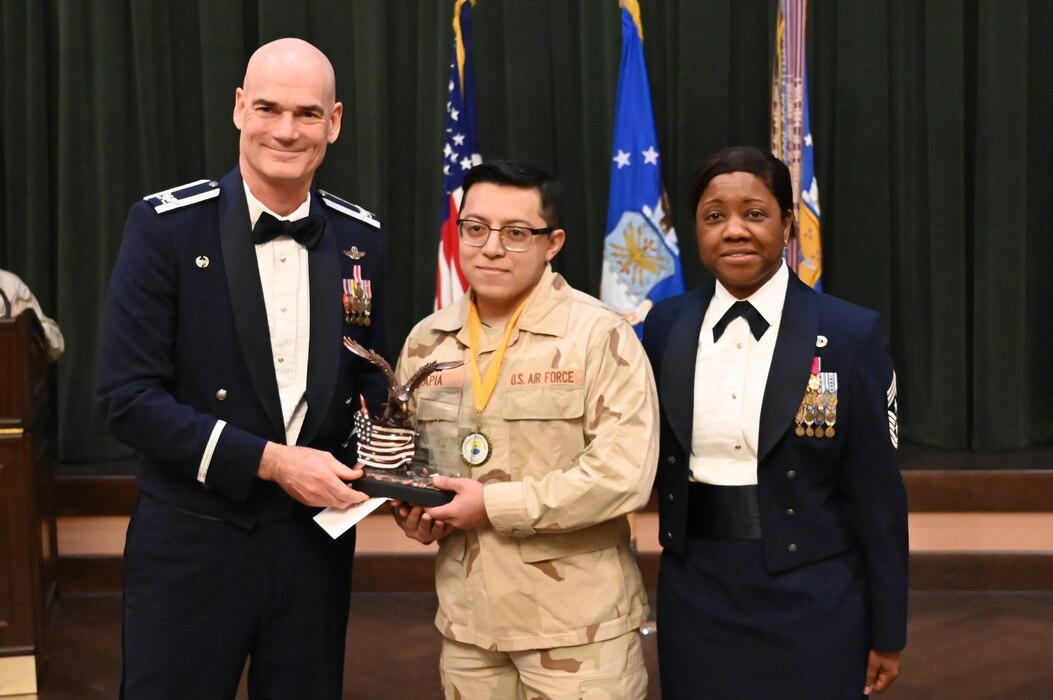 Col. William Gutermuth, 433rd Airlift Wing commander, and Chief Master Sgt. Takesha Williams, 433rd AW command chief, present the Airman of the Year award to Senior Airman Jonathan Tapia, 433rd Maintenance Group, at the wing’s annual awards ceremony Feb. 3, 2024, at Joint Base San Antonio-Lackland, Texas. (U.S. Air Force photo by Tech. Sgt. Jacob Lewis)