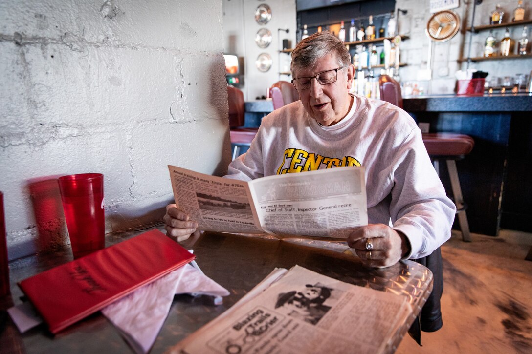 Retired Army Col. Tom Little looks through old issues of the Kentucky Guardsman at a local restaurant in Lexington, Kentucky on Jan. 17, 2024. Little, former commander of the 133rd Mobile Public Affairs detachment, donated almost 40 issues from his personal collection to the Kentucky National Guard to help preserve it's history. (Kentucky National Guard photo by Andy Dickson)