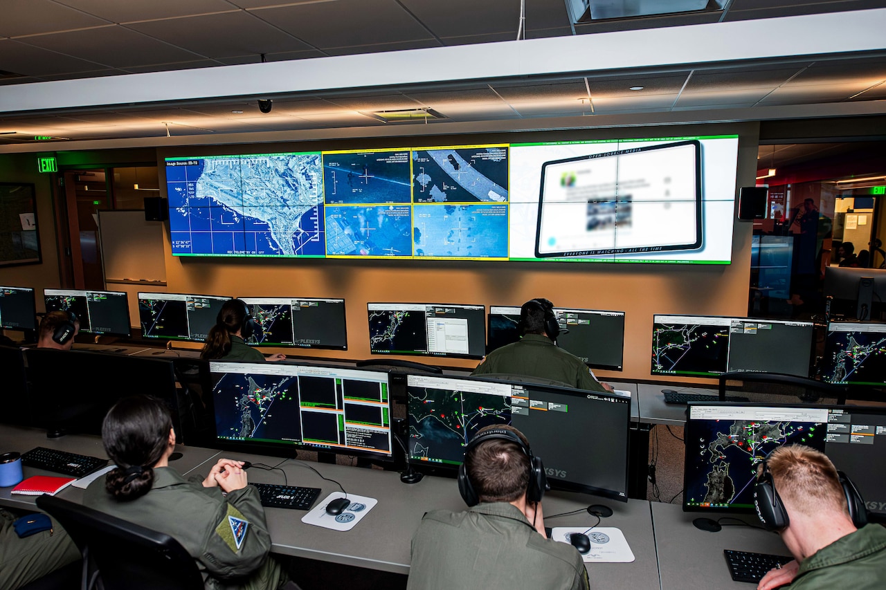 Cadets sit in front of multiple monitors.