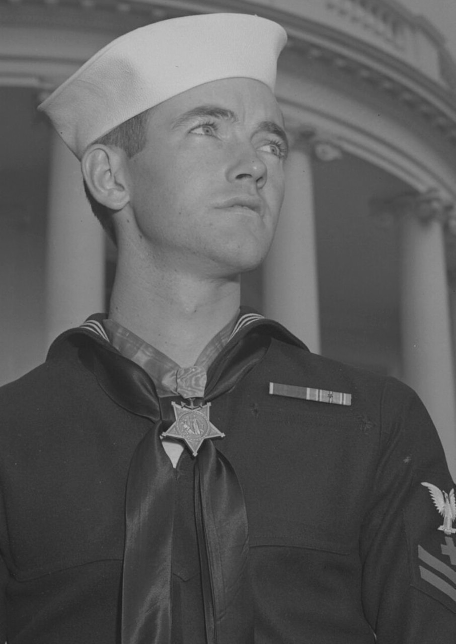 A man in uniform looks into the distance.