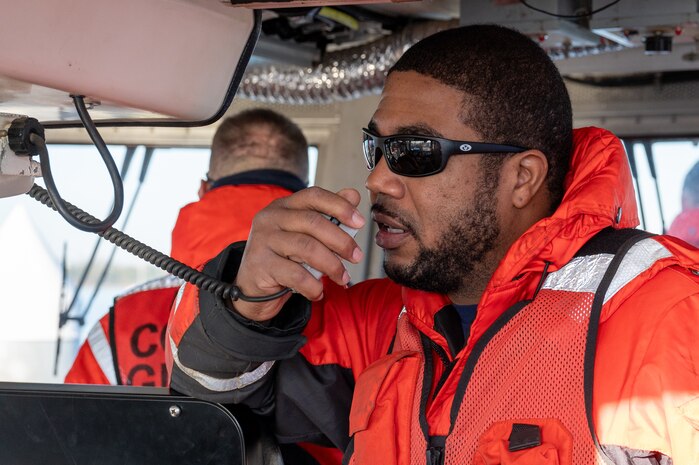 A photo of a man speaking into a radio.