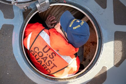 A photo of a man climbing into a hull.