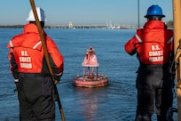 A photo of two men looking at a buoy.