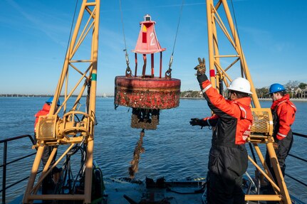 A photo of a buoy being hoisted from the water.