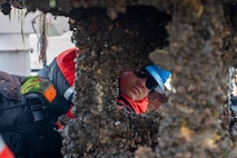 A photo of a man inspecting a buoy.