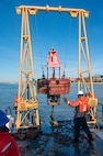 A photo of a buoy being hoisted back into the water.