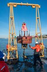 A photo of a buoy being hoisted back into the water.