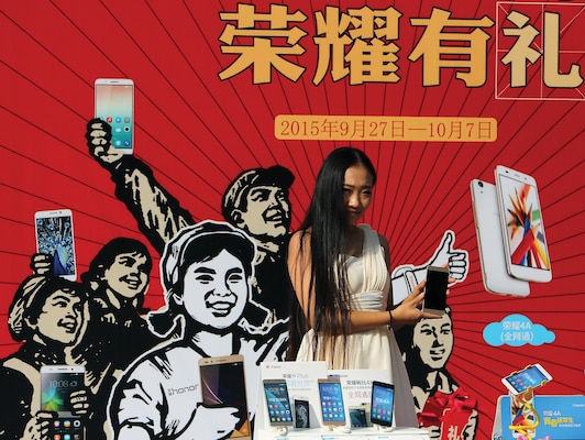 Chinese model promotes smartphone outside electronics center notorious for selling fake, gray market, and pirated electronics, in Beijing, September 27, 2015 (Stephen Shaver/UPI)