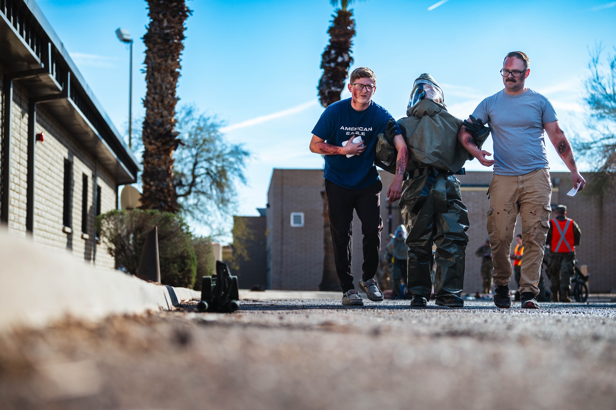 A U.S. Air Force Airman from the 56th Medical Group (middle) guides moulage patients to a decontamination tent during exercise Ready Eagle II.