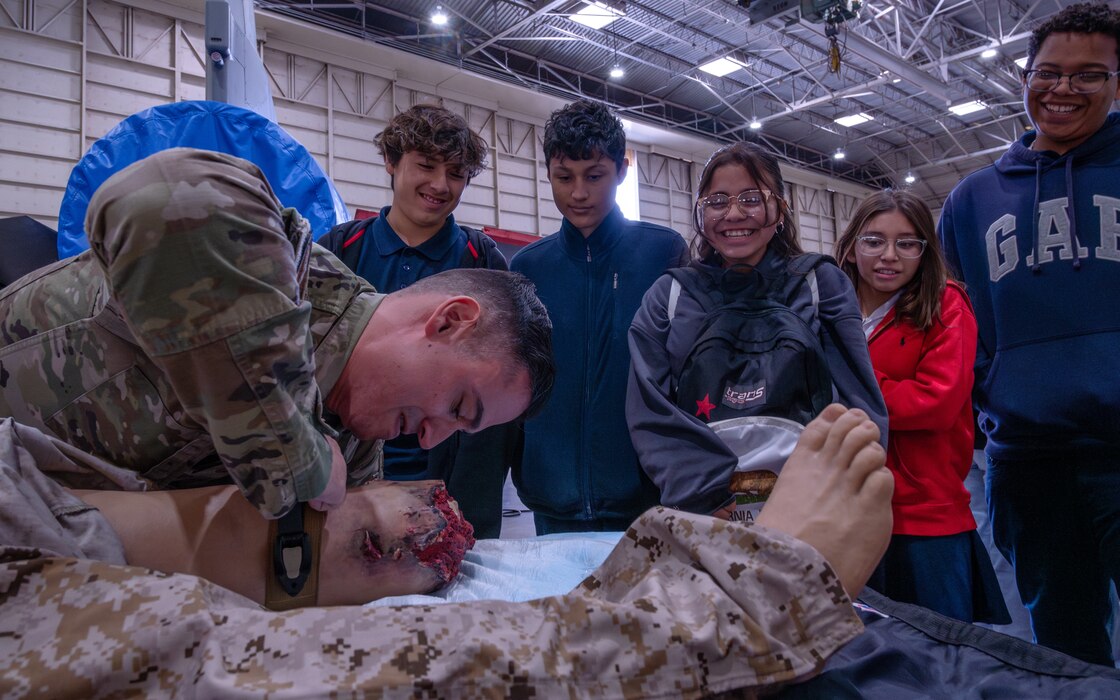 U.S. Air Force Staff Sgt. Shane Glenn, 56th Medical Group training manager, demonstrates the proper use of a tourniquet on a training dummy to students from Arthur Hamilton Junior High School during the Black History Month School Immersion, Feb. 15, 2024, at Luke Air Force Base, Arizona.