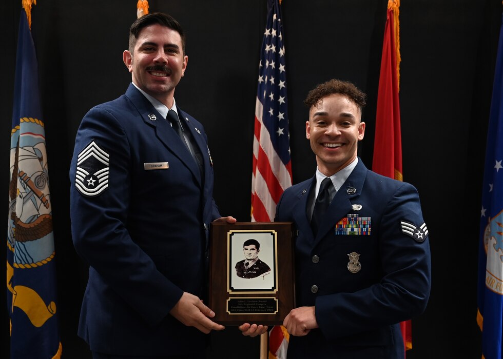 U.S. Air Force Chief Master Sgt. Daniel Graham, 47th Operations Support Squadron senior enlisted leader, presents the John L. Levitow Award to Senior Airman Reginald Conyers, 17th Security Forces Squadron defender, at the Powell Event Center, Goodfellow Air Force Base, Texas, Feb. 15, 2024. The John L. Levitow Award is the highest award offered at ALS; it is based upon all performance tasks, peer stratifications, and the capstone exercise. (U.S. Air Force photo by Senior Airman Ethan Sherwood)