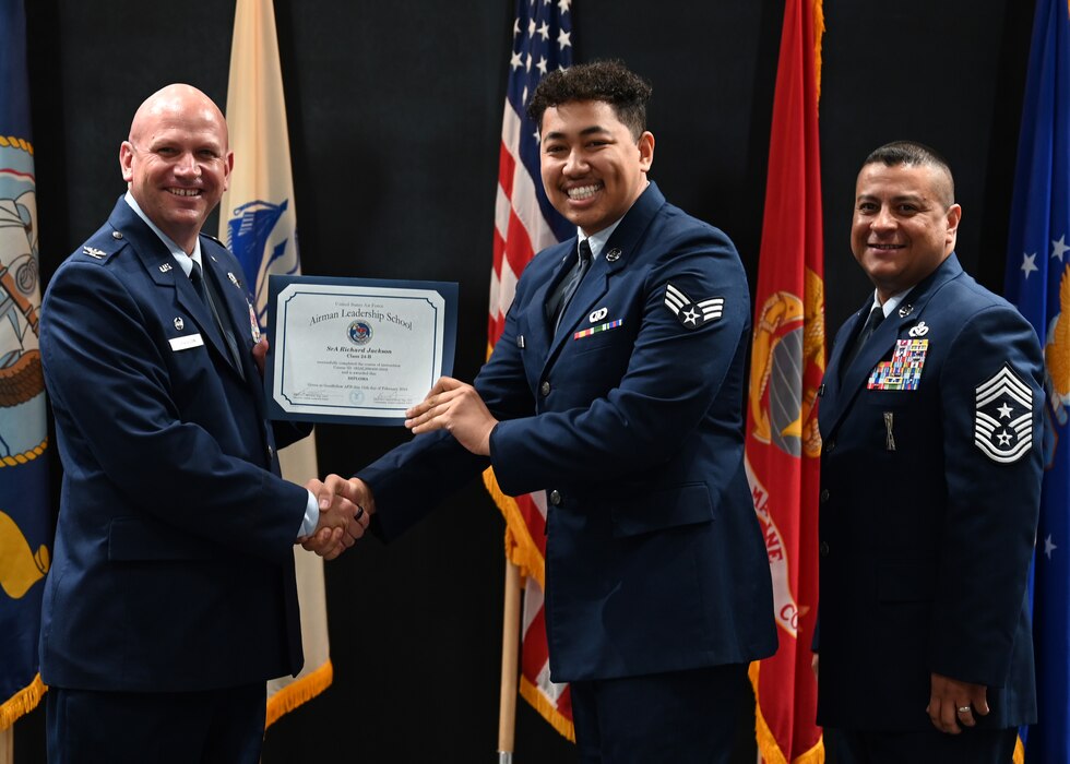 U.S. Air Force Col. Kevin Davidson, 47th Flying Training Wing commander, presents a graduation certificate to Senior Airman Richard Jackson, 47th Operations Support Squadron, at the Powell Event Center, Goodfellow Air Force Base, Texas, Feb. 15, 2024. Laughlin Air Force Base Airmen come to Goodfellow Air Force Base to attend Airman Leadership School and become front-line supervisors. (U.S. Air Force photo by Senior Airman Ethan Sherwood)