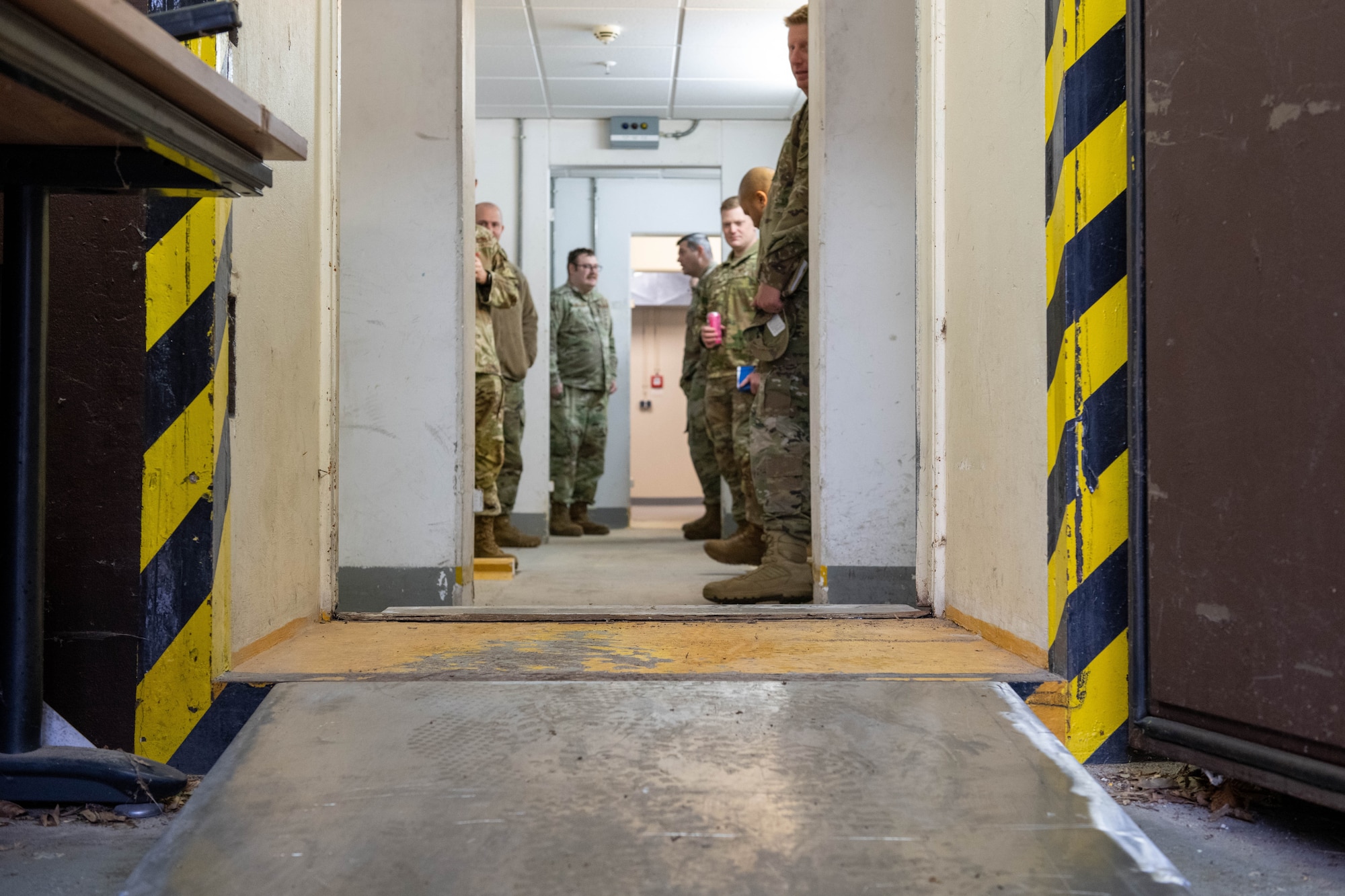 A group of people look at ramp through a door frame.
