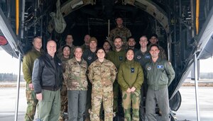 People stand in front of aircraft to pose for photo