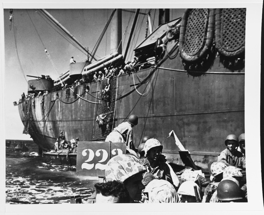 Men climbing down nets from a transport into landing craft, to be transferred to LSTs, where they will man amphibious tanks for the invasion of Kwajalein Atoll, 31 January 1944. Naval History and Heritage Command Photo.