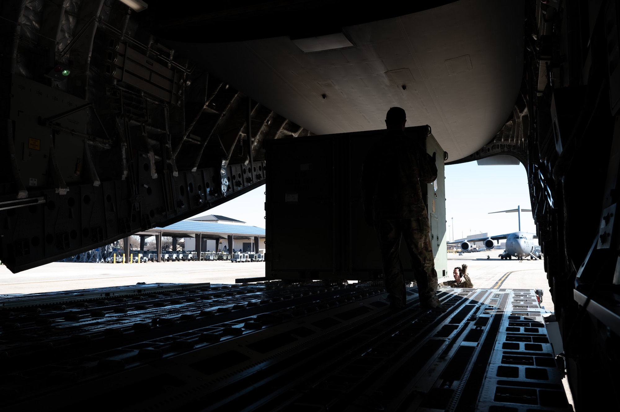 Airman assigned to the 6th Airlift Squadron load cargo onto a C-17 Globemaster III during the Tactics Advancement Course at Joint Base McGuire-Dix-Lakehurst, N.J., Feb. 7, 2024. Airmen assigned to the 6th Airlift Squadron loaded cargo onto the C-17 in order to provide support for the F-22 Raptors at Joint Base Langley-Eustis, Va. The advancements course postures Air Mobility Command Airmen to execute agile operations on a global scale. (U.S. Air Force photo by Airman 1st Class Aidan Thompson)