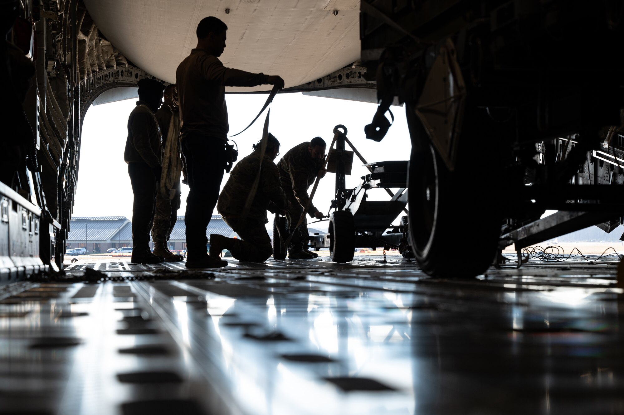 Airmen assigned to Joint Base Langley-Eustis, Va., help to load cargo onto a C-17 Globemaster III with the 6th Airlift Squadron during the Tactics Advancement Course at JBLE, Feb. 7, 2024. Airmen assigned to the 6th Airlift Squadron loaded cargo onto the C-17 in order to provide support for the F-22 Raptors at JBLE. The advancements course postures Air Mobility Command Airmen to execute agile operations on a global scale. (U.S. Air Force photo by Airman 1st Class Aidan Thompson)
