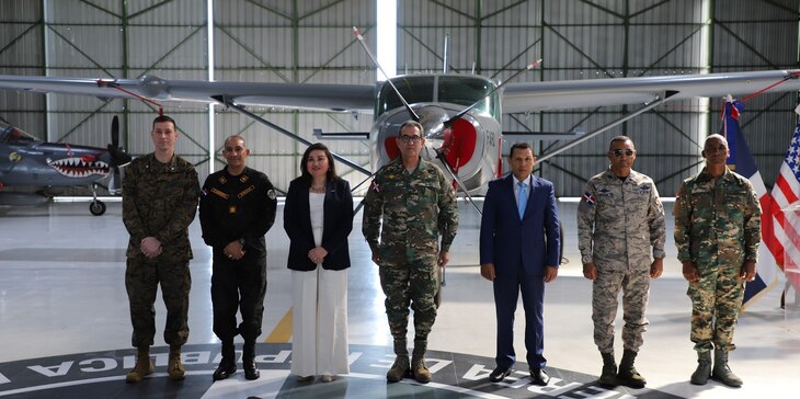 Senior U.S. and Dominican senior defense and government leaders pose for a photo in front of an aircraft.