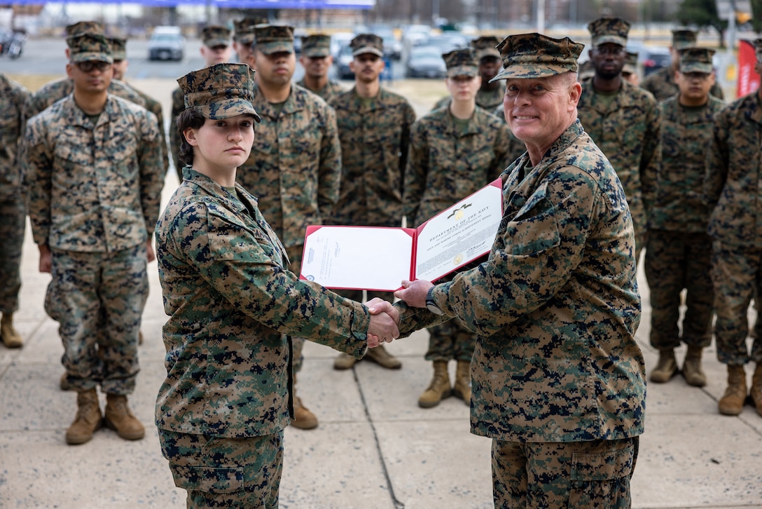 U.S. Marine Corps Lance Cpl. Marina Camponescki, a Haverhill, Massachusetts native and finance technician with Programs and Resources Department, Headquarters Marine Corps, left, receives a Navy and Marine Corps Achievement Medal from Maj. Gen. David Maxwell, commander, Marine Corps Installations Command, during an award ceremony on Marine Corps Base Quantico, Virginia, Feb. 9, 2024. Camponescki was recently selected as the MCICOM Marine of the Year and was awarded for her superior work ethic. (U.S. Marine Corps photo by Lance Cpl. Joaquin Dela Torre)