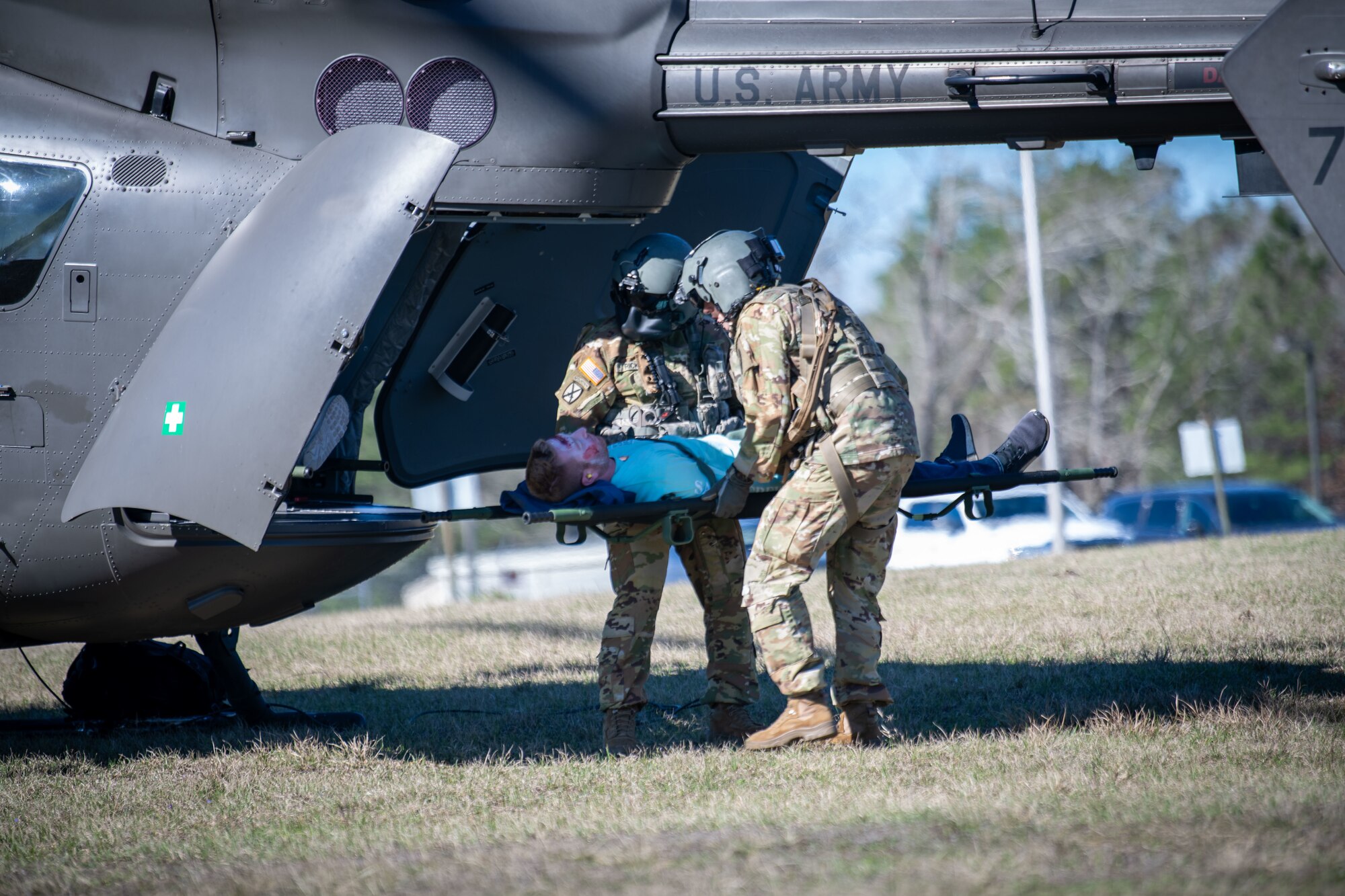 Servicemen load an injured role-play victim to a UH-72 Lakota helicopter for transport during a PATRIOT 24 search and rescue exercise, Camp Shelby, Mississippi, Feb. 19, 2024.