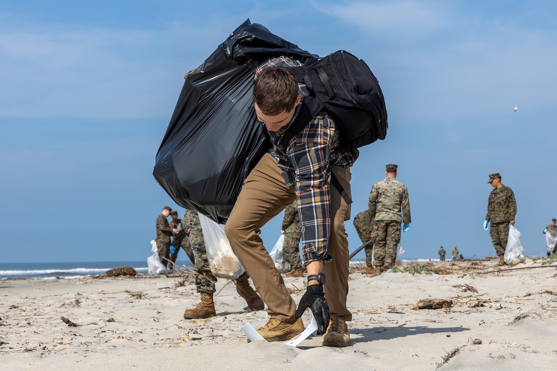 Chase Conrad, the hazardous waste chief with the Marine Corps Base Camp Pendleton Environmental Security Department, collects a piece of trash during a beach cleanup at White Beach at MCB Camp Pendleton, California, Feb. 16, 2024. This cleanup allows MCB Camp Pendleton and its tenant units to conduct preservation efforts while harmonizing environmental efficacy and military readiness. MCB Camp Pendleton takes active steps to preserve regional wildlife and natural resources while providing the Fleet Marine Force with the training spaces necessary to meet training and readiness requirements. (U.S. Marine Corps photo by Lance Cpl. Watts)